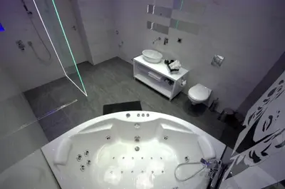 a white bathroom with a tub and a shower at Monroe Apartment in Belgrade