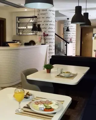 a table with a plate of food and drinks on it at Passport Belgrade in Belgrade