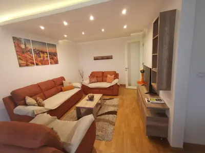 a living room with two couches and a tv at Twin Belville Apartments in Belgrade