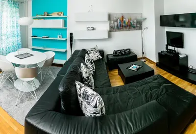 a living room with a black couch and a table at Twin Belville Apartments in Belgrade