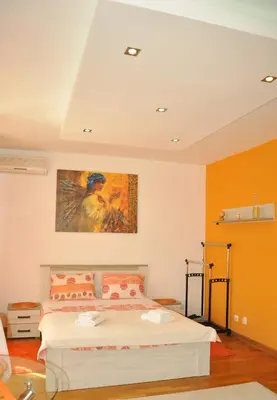 a bedroom with a bed and a painting on the wall at Twin Belville Apartments in Belgrade