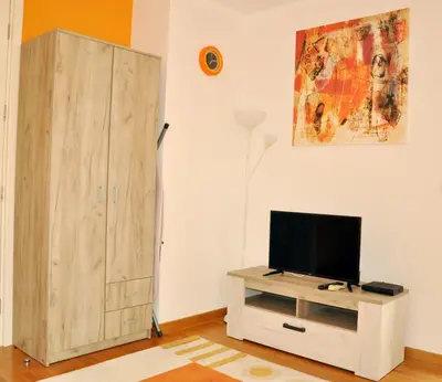 a living room with a tv and a cabinet at Twin Belville Apartments in Belgrade