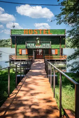 a building on a dock in the water at Green House Hostel in Belgrade