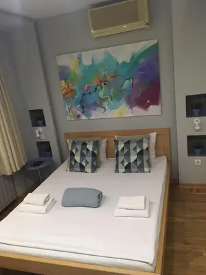 a bed in a room with a painting on the wall at L9 Top Central Rooms and Apartments 2 in Belgrade