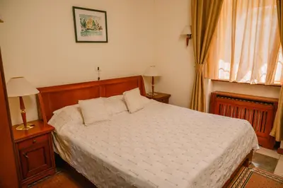 a bedroom with a bed and two lamps and a window at Kaštel Ečka in Ečka