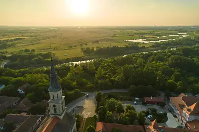 an aerial view of a town with a church tower at Kaštel Ečka in Ečka