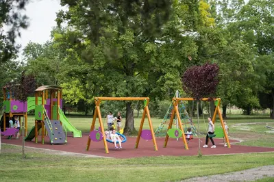 a group of children playing on a playground in a park at Kaštel Ečka in Ečka