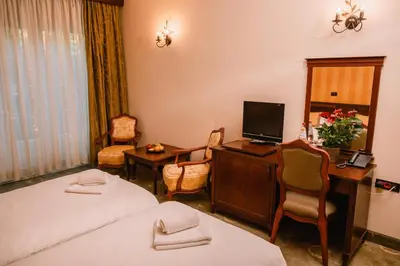 a hotel room with a bed and a desk with a computer at Kaštel Ečka in Ečka