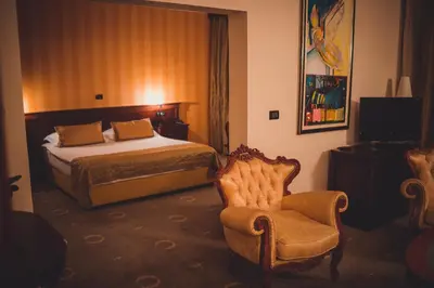 a hotel room with a bed and a chair at Kaštel Ečka in Ečka