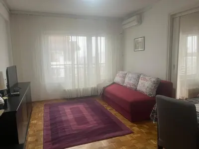 a living room with a red couch and a tv at Danube Apartment in Belgrade