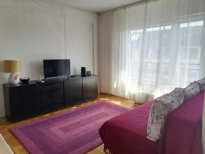 a bedroom with a bed and a tv and a window at Danube Apartment in Belgrade