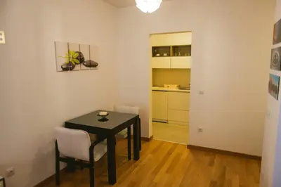 a small dining room with a black table and chairs at Maja Apartment in Belgrade