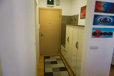 a kitchen with a hallway with a door and a rug at Maja Apartment in Belgrade