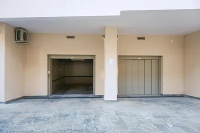 an empty room with two garage doors and a pillar at Maja Apartment in Belgrade