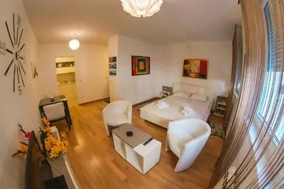a bedroom with a bed and a living room at Maja Apartment in Belgrade