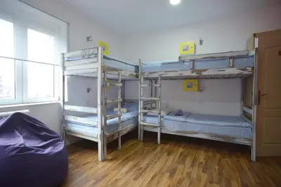 a room with three bunk beds and a wooden floor at Stella Di Notte in Belgrade