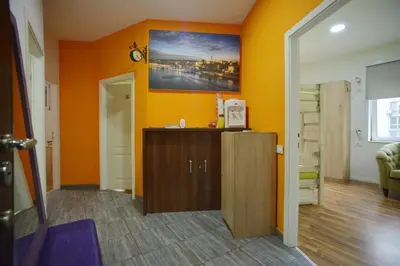a living room with orange walls and a wooden cabinet at Stella Di Notte in Belgrade