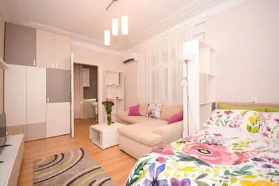 a bedroom with a bed and a living room at Apartment Mina in Belgrade