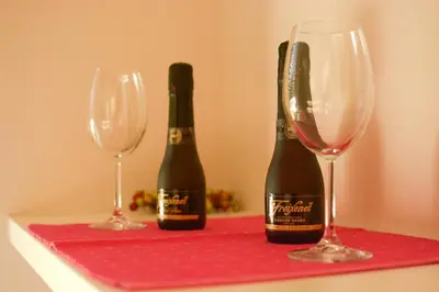 two bottles of champagne and two glasses on a red table at Apartment Mina in Belgrade