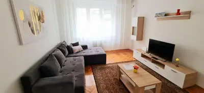 a living room with a couch and a tv at Downtown Star Apartment in Belgrade