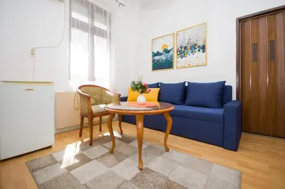 a living room with a blue couch and a table at Downtown Star Apartment in Belgrade