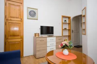 a living room with a table and a tv at Downtown Star Apartment in Belgrade