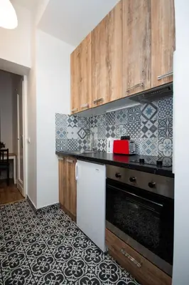 a kitchen with wooden cabinets and a black counter top at Downtown Star Apartment in Belgrade