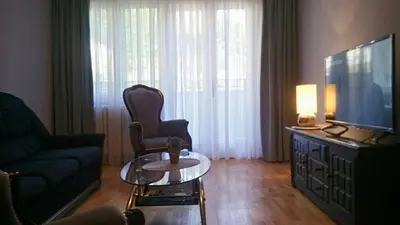 a living room with a couch and a tv and a table at Apartment Zindan in Belgrade