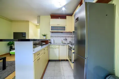 a kitchen with white cabinets and a stainless steel refrigerator at Panorama Central Apartments in Belgrade