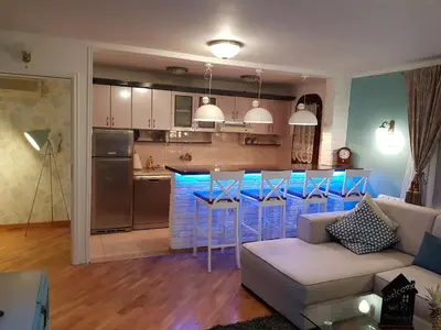 a living room and kitchen with a couch and a bar at Victory Dedinje in Belgrade