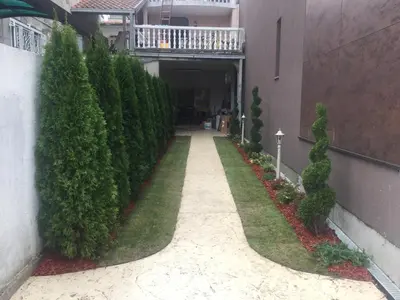 a walkway in a building with bushes and trees at Victory Dedinje in Belgrade
