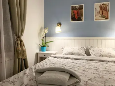 a bedroom with a bed and a curtain and a table at Victory Dedinje in Belgrade