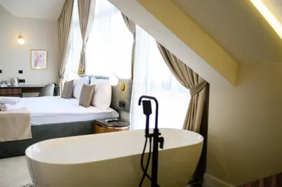 a bathroom with a bath tub and a bed at Hotel Bohemian Garni - Skadarlija in Belgrade