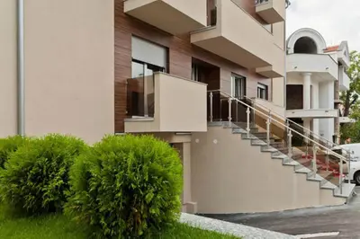 a building with stairs and bushes in front of it at Lazic Apartment in Belgrade