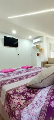 a bedroom with a large bed with a purple blanket at Maslina Rooms in Smederevo