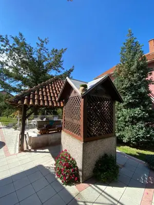a bird house in a garden with a gazebo at Maslina Rooms in Smederevo