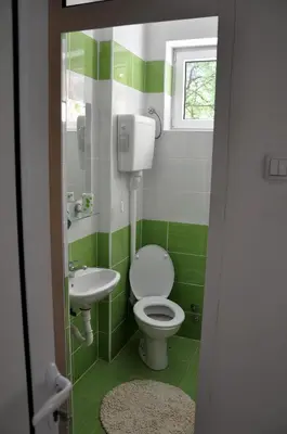 a green and white bathroom with a toilet and sink at Rooms Karadjordje in Belgrade