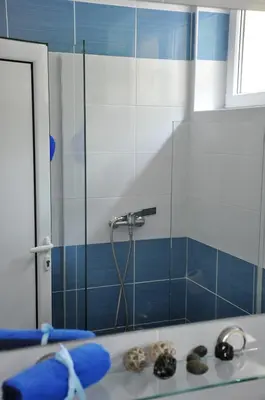 a bathroom with a shower with blue and white tiles at Rooms Karadjordje in Belgrade