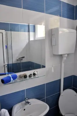 a blue and white bathroom with a toilet and a sink at Rooms Karadjordje in Belgrade