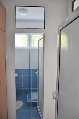 a bathroom with a glass shower door and blue tiles at Rooms Karadjordje in Belgrade
