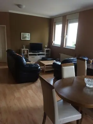 a living room with black leather furniture and a table at Aleksandar Apartment in Pančevo
