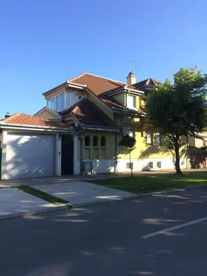 a large house with a garage on a street at Aleksandar Apartment in Pančevo