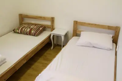 two twin beds in a room with a night stand at Hostel Jellostone in Belgrade