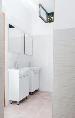 a white bathroom with two sinks and a mirror at Hostel Jellostone in Belgrade