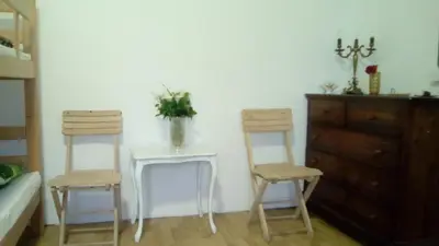 a room with two chairs and a table with a vase on it at Hostel Jellostone in Belgrade
