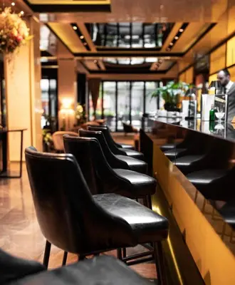 a row of chairs sitting at a bar in a restaurant at SAINT TEN Boutique Hotel, Small Luxury Hotels in Belgrade