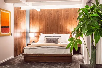a bedroom with a bed with a wooden headboard at Nomad Luxury Suites in Belgrade