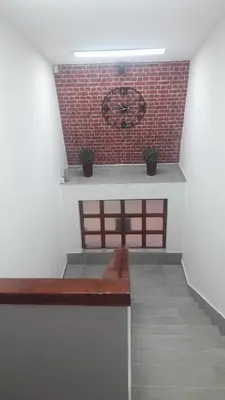 a bench in a room with a clock on a wall at Blue Danube Apartment in Belgrade