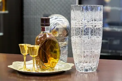 a bottle of whiskey and two glasses on a table at Hotel Sterling Garni in Belgrade