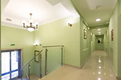 a hallway with green walls and a chandelier at Hotel Sterling Garni in Belgrade